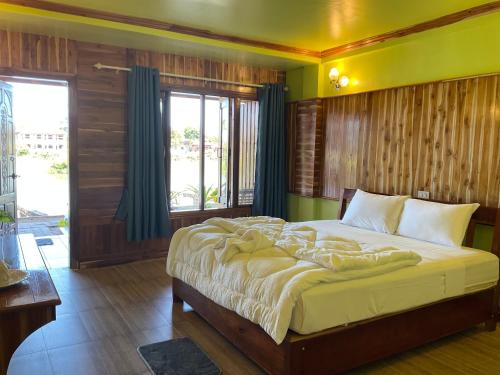 a bedroom with a large bed in a room at Pan guest house Donkhone in Ban Donsôm