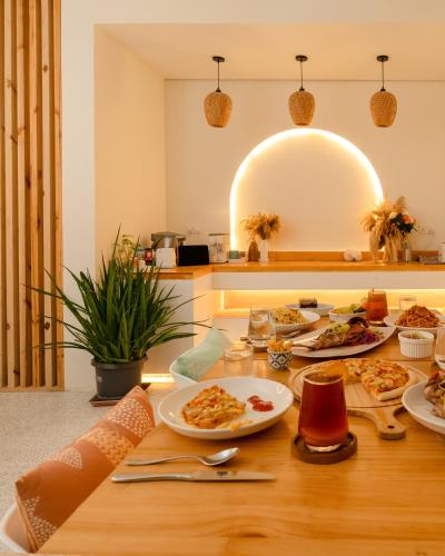 a wooden table with plates of food on it at Niru Isle Maldives in Gaafaru