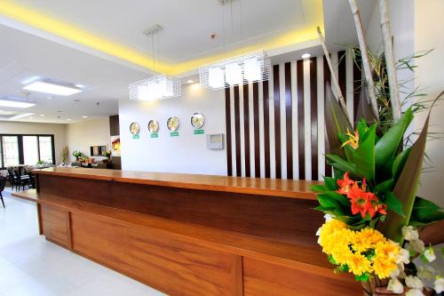 a lobby with a reception desk with flowers on the counter at Coron Soleil Express Hotel in Coron