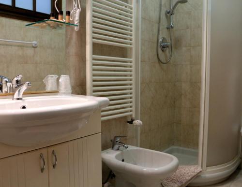 a bathroom with a sink and a toilet and a shower at Hotel La Quiete in Bardonecchia