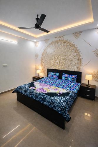 a bedroom with a large bed with blue pillows at Drop Hills Farm Noida in Noida