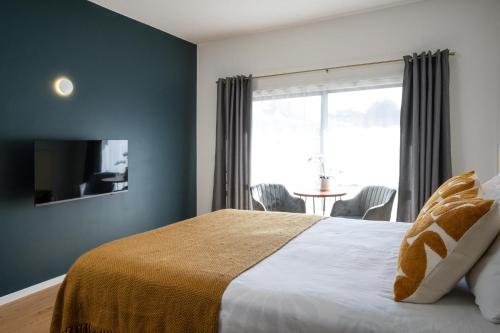 a bedroom with a bed with a window and a table at Mt Wellington Motel in Auckland