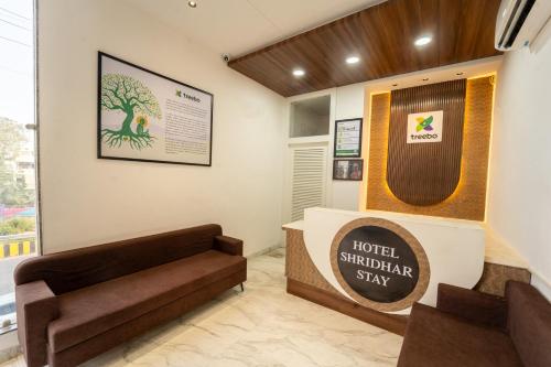 a hotel shilling room with a sign and a couch at Treebo Shridhar Stay, 2 km from Indore Junction in Indore