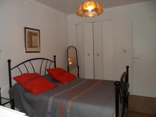 a bedroom with a bed with red pillows on it at Appartement Sole e Mare in Furiani