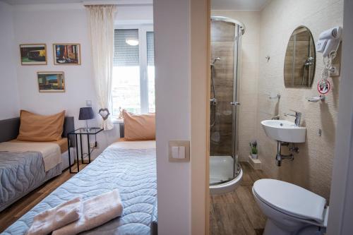 a bedroom with a bed and a bathroom with a shower at Къща за гости ЕМА in Vetren Dol