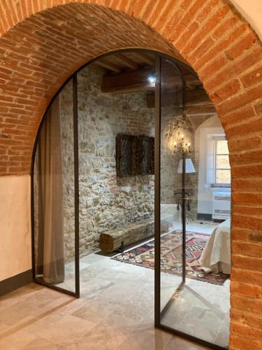 a room with a stone wall and a glass doorway at Appartamento Monache in Lucignano