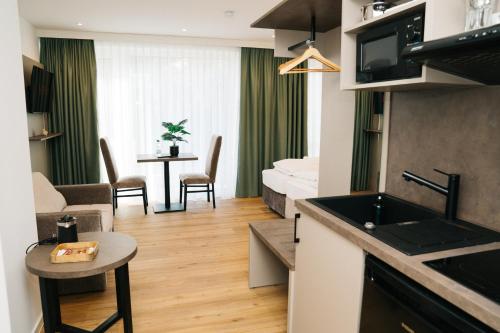 a room with a kitchen and a living room at Living Inn am Schlosspark - Zentral, Parkplatz und Kitchenette in Rheda-Wiedenbrück