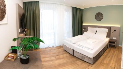 a bedroom with a large white bed in a room at Living Inn am Schlosspark - Zentral, Parkplatz und Kitchenette in Rheda-Wiedenbrück