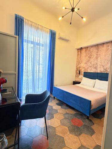 a bedroom with a bed and a chair and a window at Dimora San Lorenzo in Taranto