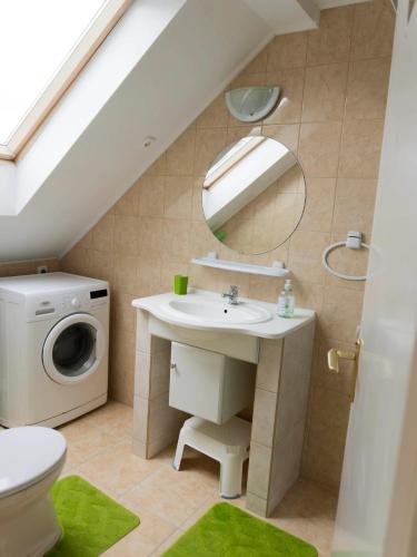a bathroom with a sink and a washing machine at Katyca Apartman in Balatonfüred