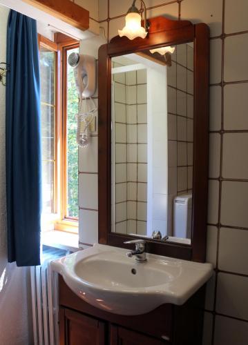 a bathroom with a sink and a mirror and a window at Hotel La Quiete in Bardonecchia