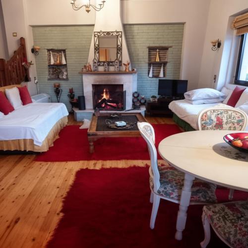 a living room with two beds and a fireplace at Amadrias Villa Florina in Florina