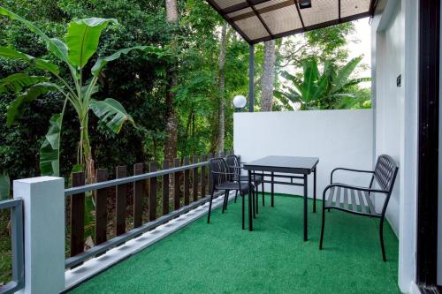 a patio with a table and chairs on a balcony at P Square Villa in Ban Krabi Yai