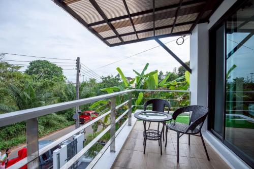 a balcony with a table and chairs on it at P Square Villa in Ban Krabi Yai