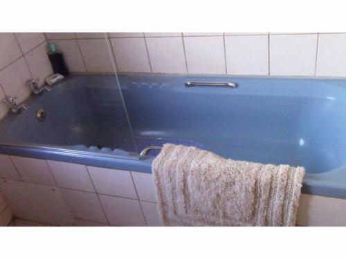 a blue bath tub in a bathroom with a towel at Forest Nest in Stormsrivier