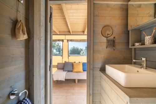 a bathroom with a sink and a couch in the background at Procida Camp & Resort - Ciraccio in Procida