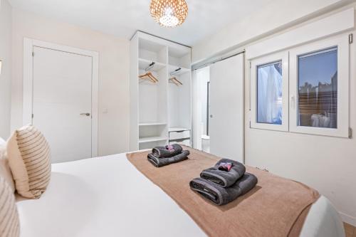 a bedroom with a large white bed with two slippers at VICTORIA 75 LUXURY in Málaga