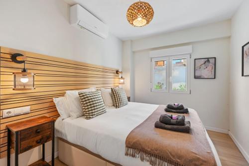 a bedroom with a large bed with a wooden headboard at VICTORIA 75 LUXURY in Málaga