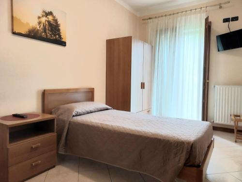 a bedroom with a bed and a dresser and a window at Locanda "Alla Rosa" in Lusiana