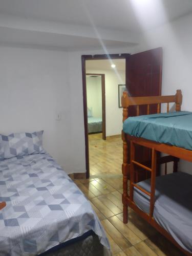 a bedroom with a bed and a bunk bed at Casa temporada próximo a praça do canhão in São Pedro da Aldeia