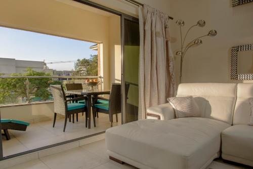 a living room with a white couch and a table and chairs at The Landmark Suites in Nairobi