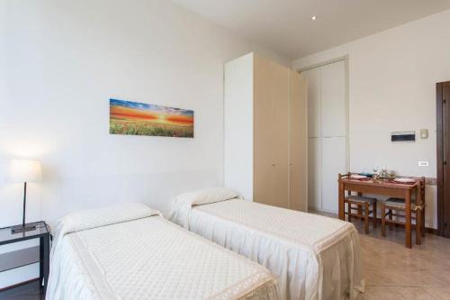 Zimmer mit 2 Betten, einem Tisch und einem Schreibtisch in der Unterkunft Appartamento Via Rovetta in Mailand