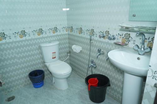 a bathroom with a toilet and a sink at Hotel Grand Shah Kamal in Sylhet