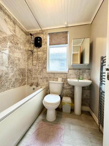 a bathroom with a toilet and a sink at Comfortable rooms Manchester in Manchester