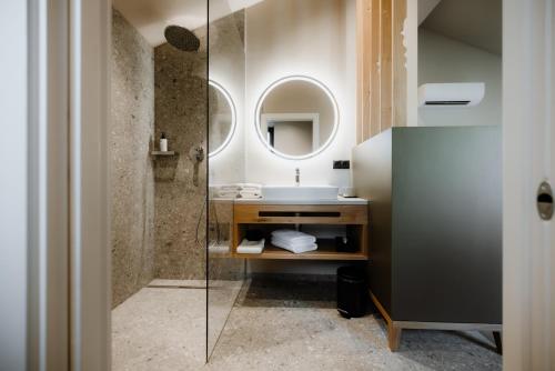 a bathroom with a sink and a mirror at Stricker Aparthotel in Tirolo