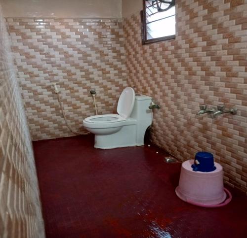 a bathroom with a toilet in a brick wall at ComfortInn in Chennai