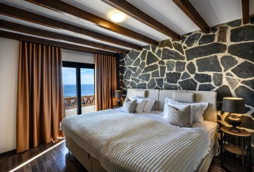 a bedroom with a large bed and a stone wall at Palacio de Cantalobos in Almuñécar