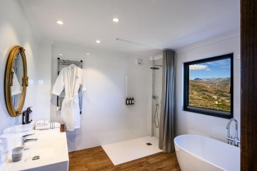 a white bathroom with a tub and a window at Palacio de Cantalobos in Almuñécar