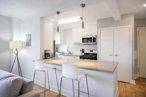 a kitchen with white cabinets and white bar stools at Luxury 2 Bedroom 2 Bathroom Residence Great View in Los Angeles