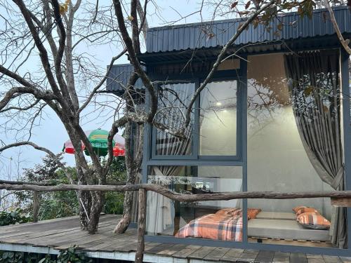 a bed in a window of a house at Vuon Hong Le Phuc-Cau Dat Glamping Retreat Da Lat in Ấp Trạm Hành