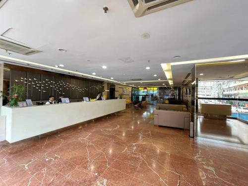 a lobby of a building with people sitting at a counter at Seeds Hotel Premier Pudu TRX Kuala Lumpur in Kuala Lumpur