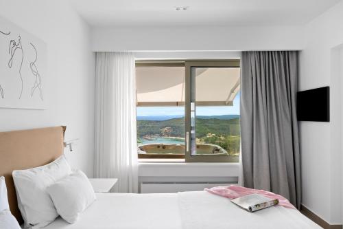 a bedroom with a bed and a large window at LIVINGHOME SUITES in Parga