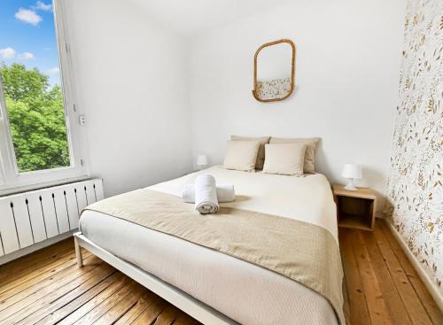 a white bedroom with a bed with a mirror on the wall at Superbe T3 familial et rénové au cœur de la ville - Proche Paris in Alfortville