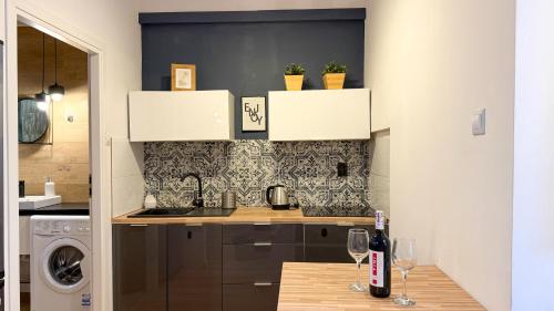 a kitchen with a counter with two glasses of wine at Zapisane w Cegle by LibertaRent in Świdnica