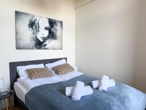 a bedroom with a bed and a painting on the wall at Zapisane w Cegle by LibertaRent in Świdnica
