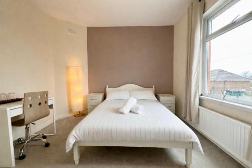a bedroom with a bed and a desk and a window at Comfortable rooms Manchester in Manchester