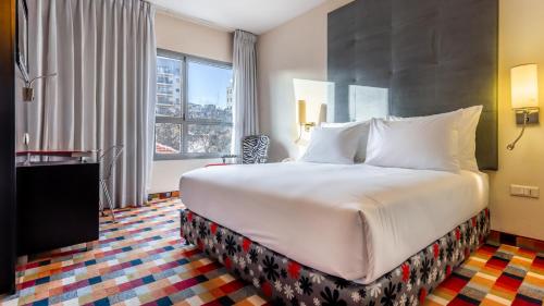 a hotel room with a large bed and a window at Jacob Harmony in Jerusalem