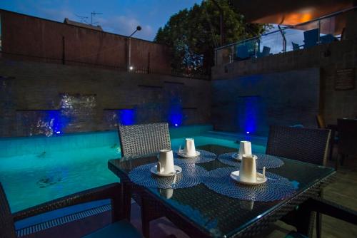 una mesa con sillas junto a una piscina en The Landmark Suites en Nairobi