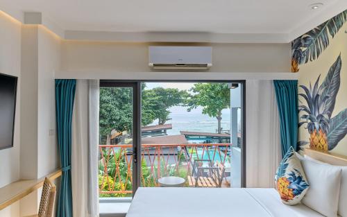 a bedroom with a bed and a view of the ocean at Lub d Koh Samui Chaweng Beach - Beachfront & Vibrant Social Vibe in Chaweng