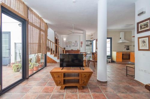 a living room with a tv and a table in it at GuestReady - Marea La Graciosa relax para familias in Caleta de Sebo