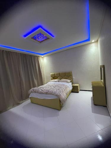 a bedroom with a bed and a blue light at Villa haut standing vue mere in Kenitra