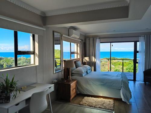 a bedroom with a bed with a view of the ocean at Cove View B&B in East London