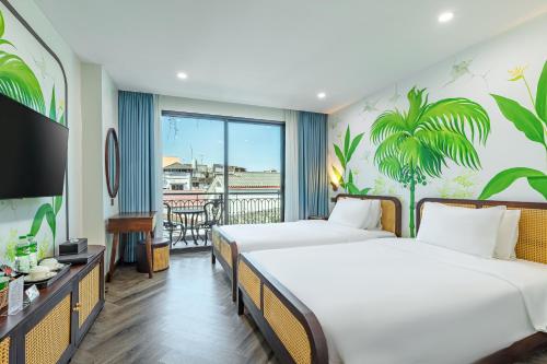 a hotel room with two beds and a balcony at The Green Hotel Vientiane in Vientiane