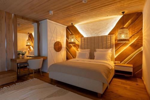 a bedroom with a bed and a table and a desk at Prispa Premium Resort in Vişeu de Sus