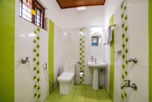 a bathroom with a toilet and a sink at Backwater Home in Kumarakom