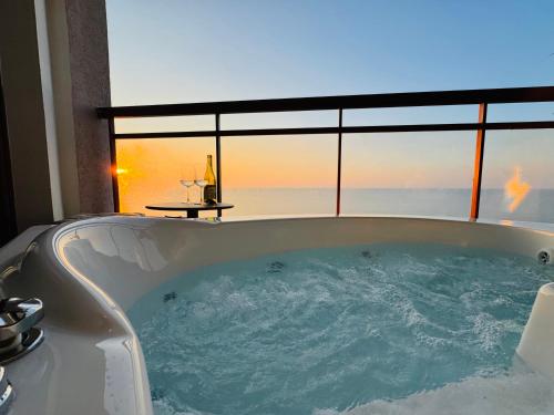 a bath tub with a view of the ocean at קו המים - Waterline סוויטות עם גקוזי הכי קרוב לים in Netanya